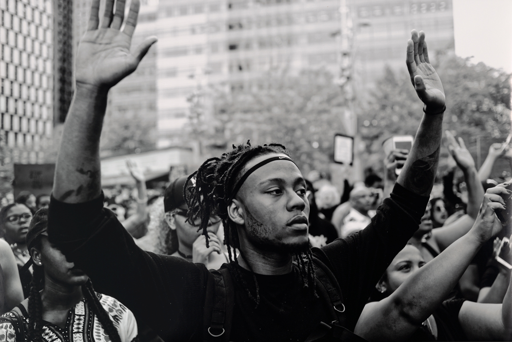 Protester with his arms up in a crowd